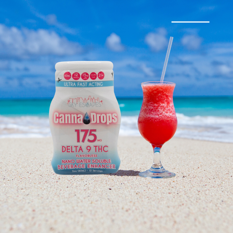 CannaDrops Delta 9 THC beverage enhancer on tropical beach next to fruity red cocktail – 175mg fast-acting flavorless THC drops for summer drinks.