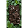 Mint chocolate bar topped with crushed chocolate cookies on fresh mint leaves.